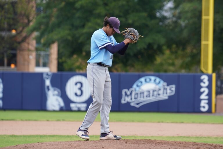 A focused baseball pitcher prepares to throw on the field during a game.