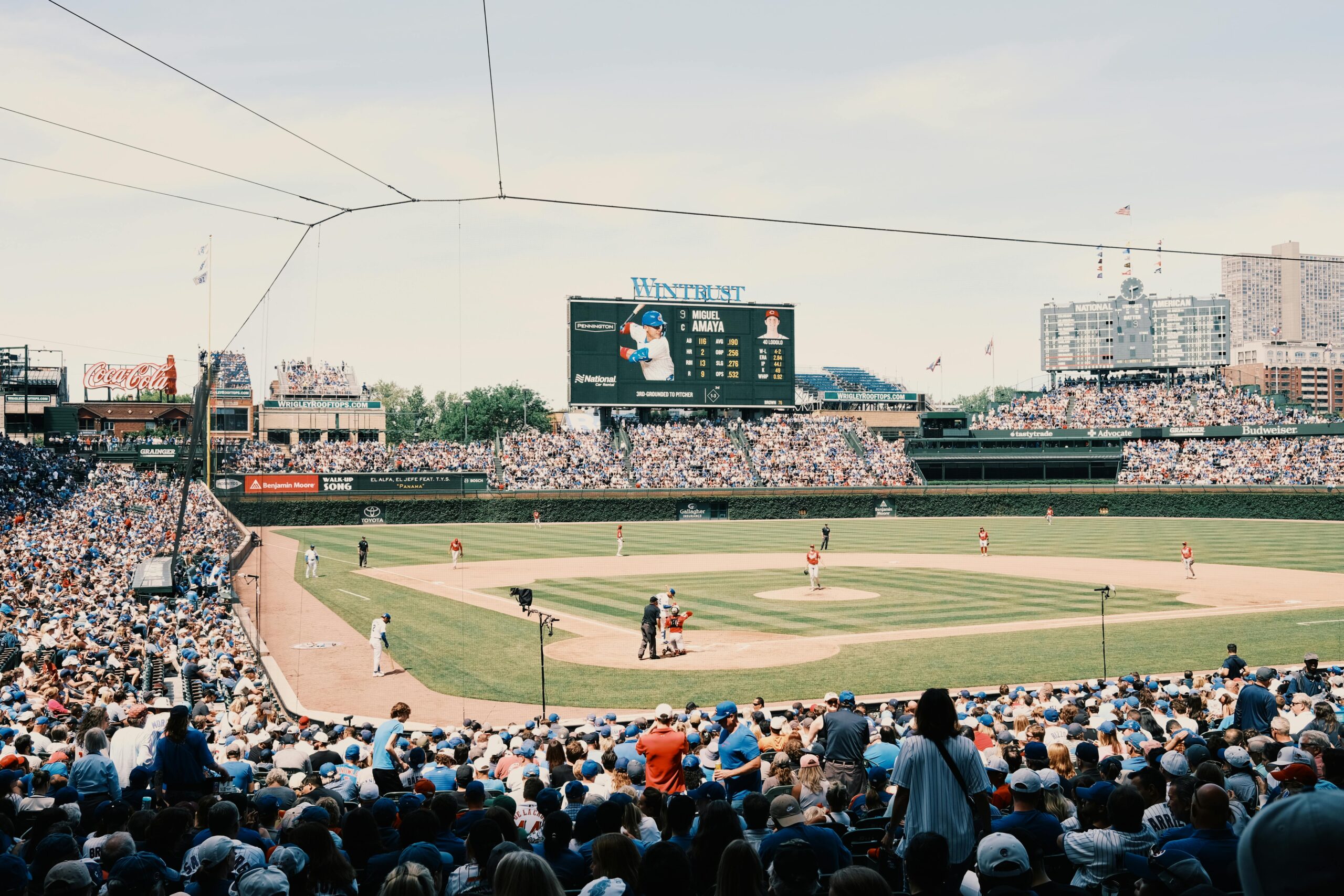 A lively baseball game at Wrigley Field with a packed stadium and urban skyline.
